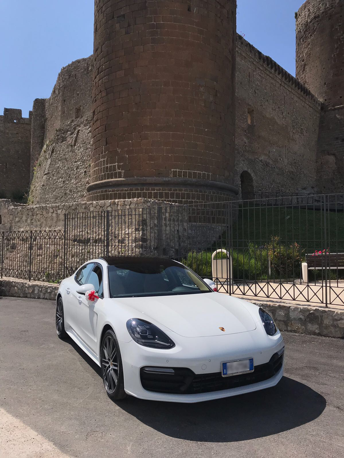 La nuova Porsche panamera con addobbi bianchi e rossi scelto e voluti dagli sposi per mantenere il tema del matrimonio.